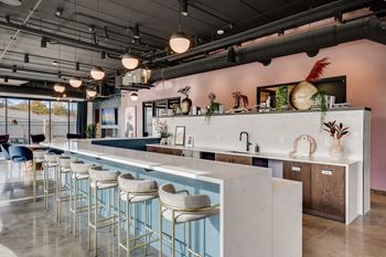 the bar area of a restaurant with white counter tops and blue stools
